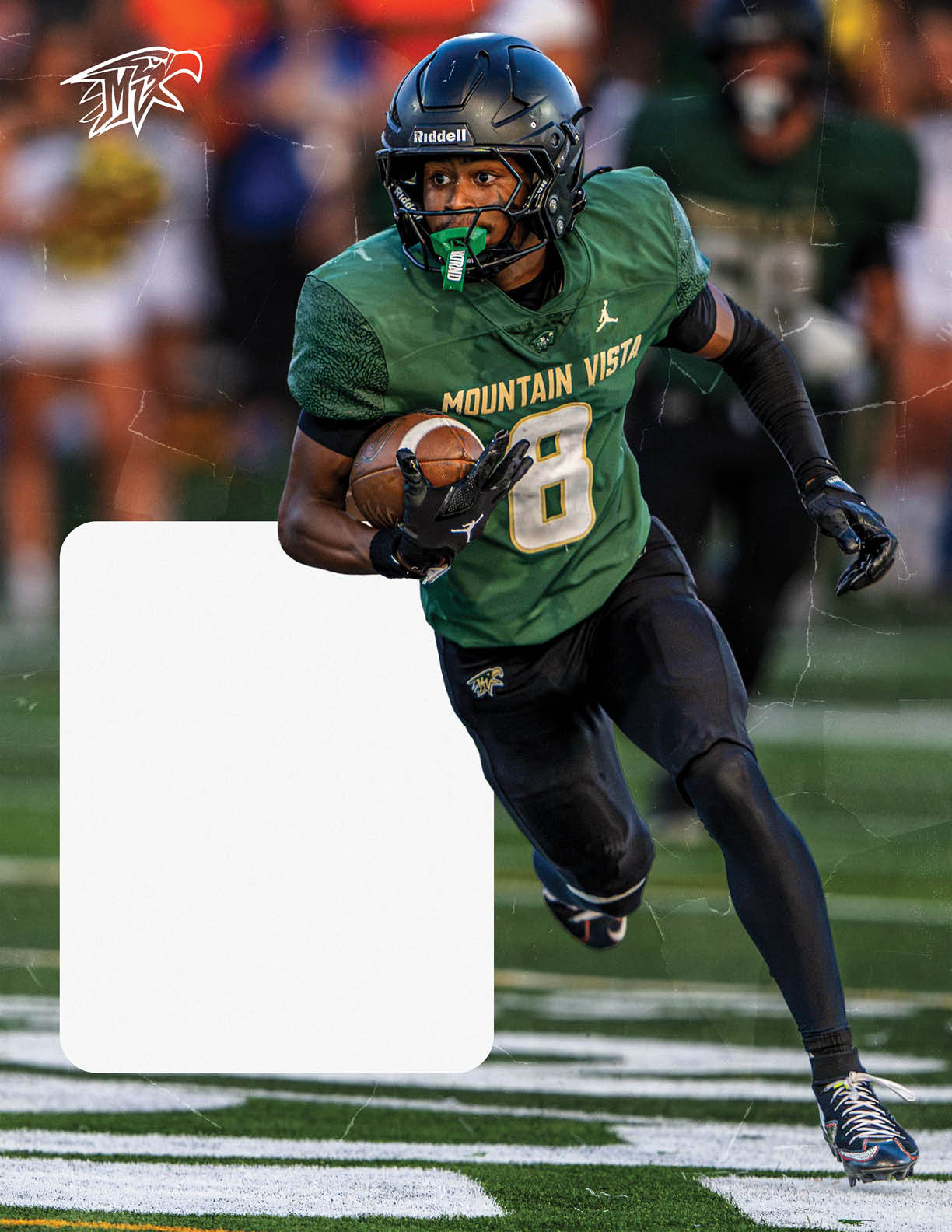 A person wearing a green Mountain Vista football uniform and helmet is running on a field while holding a football. Description generated by AI
