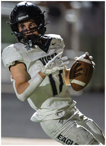 A person wearing a football uniform and helmet is in the motion of throwing a football on a field. Description generated by AI