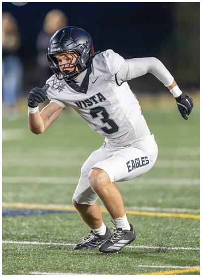 A person wearing a white football uniform with the number 3 and a black helmet is crouched in an athletic stance on a football field. Description generated by AI