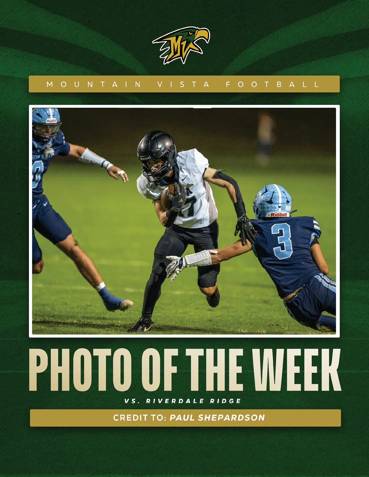 A person in black and white football gear is running with the ball while two people in blue football uniforms attempt to tackle them on a field at night. Description generated by AI