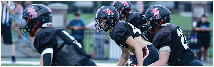 A group of football players wearing black and red uniforms. Description generated by AI