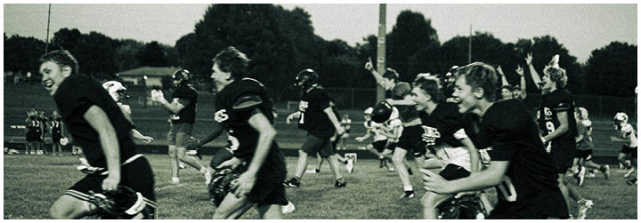 A group of people running on a grassy field. Description generated by AI