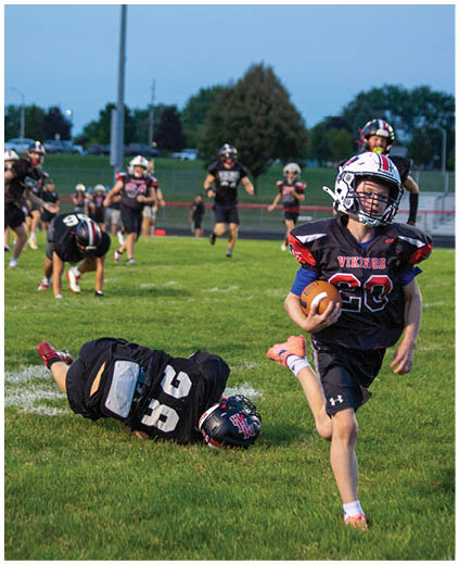A football player is running with a football. Description generated by AI