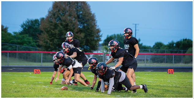 A group of football players on a field. Description generated by AI