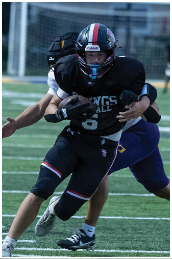 A football player running with the ball. Description generated by AI