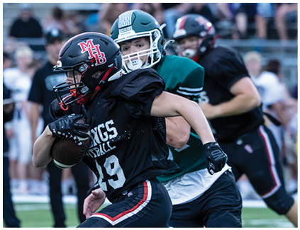 A football player running with a football. Description generated by AI