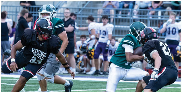 A football player in a black jersey is running with the ball. Description generated by AI