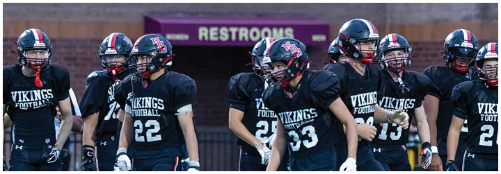 A group of football players wearing black and red uniforms. Description generated by AI