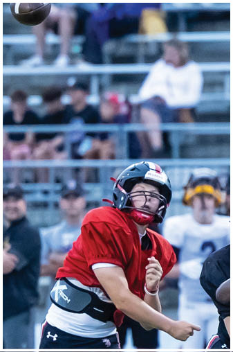 A football player wearing a red jersey and black helmet. Description generated by AI