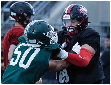 Two football players are fighting on the field. Description generated by AI