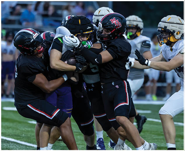A group of football players on a field. Description generated by AI
