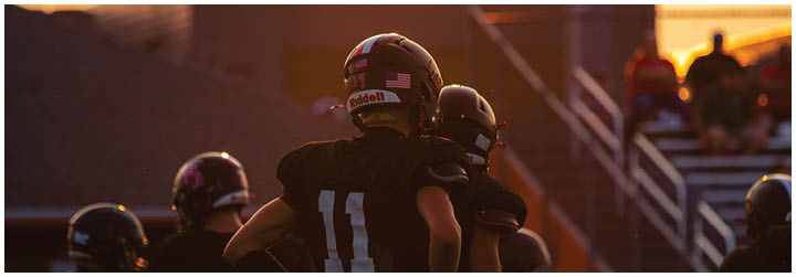 A group of football players standing on a field. Description generated by AI
