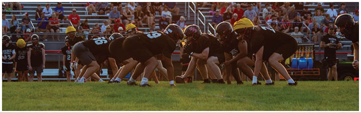 A football field with a group of people on it. Description generated by AI