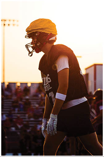 A football player wearing a helmet and a black jersey. Description generated by AI