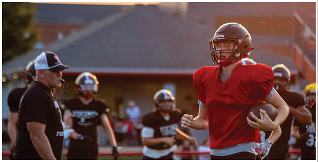 A football player in a red jersey and white shorts. Description generated by AI