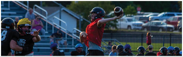 A football player in a red shirt throws a football. Description generated by AI