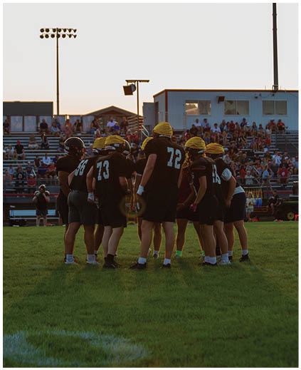 A group of football players on a field. Description generated by AI