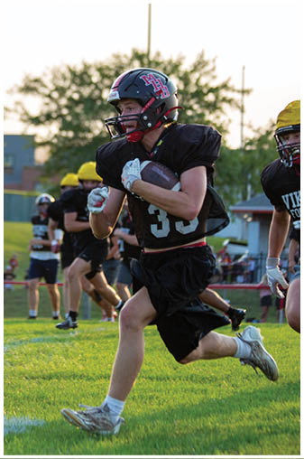 A football player running with a ball. Description generated by AI