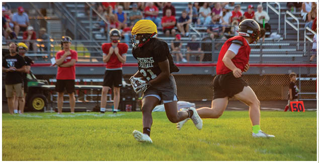 A football player running on the field. Description generated by AI