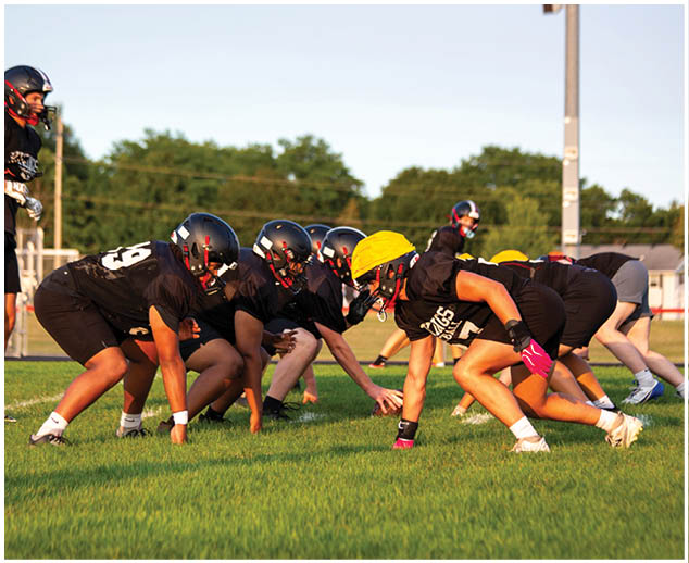 A group of football players in black and yellow uniforms. Description generated by AI