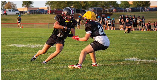 Two football players on a field. Description generated by AI