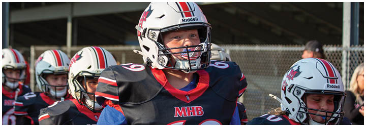 A group of football players wearing black jerseys with the number 69. Description generated by AI