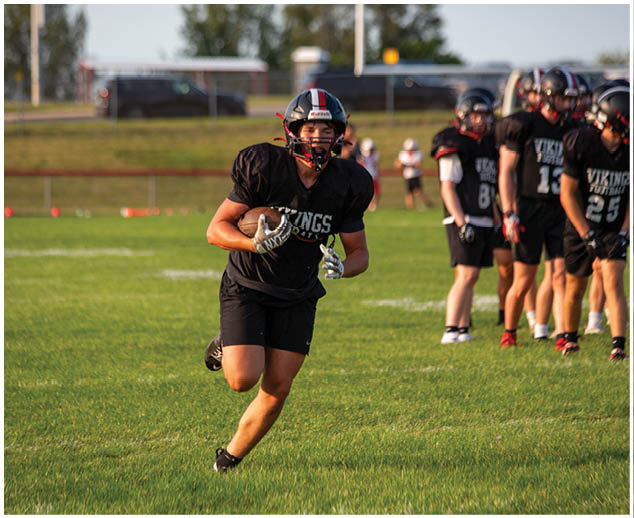 A football player running with a football. Description generated by AI