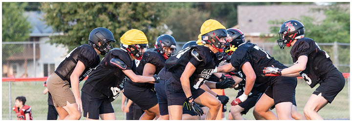 A group of football players on a field. Description generated by AI