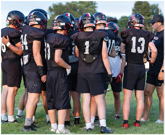 A group of football players wearing black jerseys. Description generated by AI