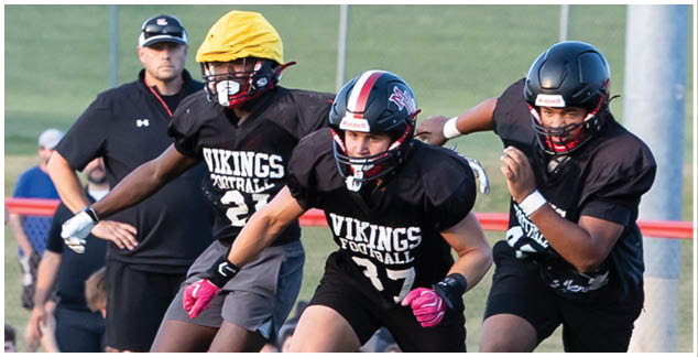 A football player wearing a black helmet and jersey with the number 23. Description generated by AI