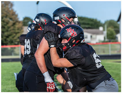 A group of football players on a field. Description generated by AI
