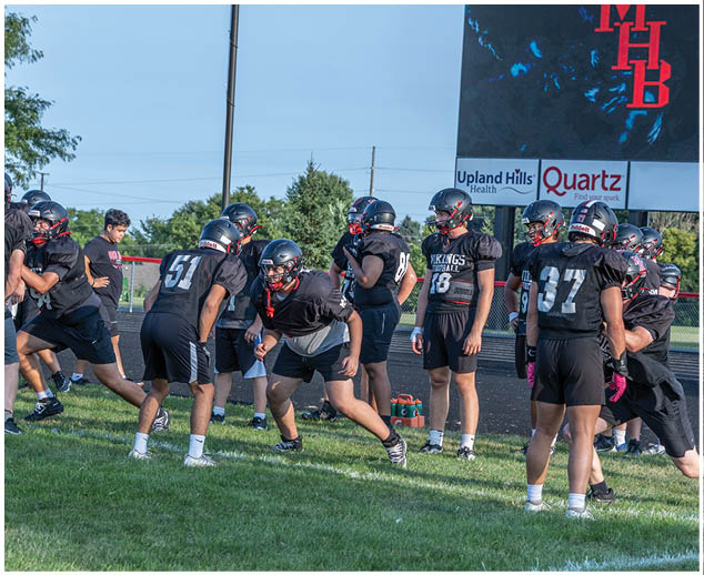 A group of football players on a field. Description generated by AI