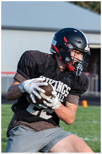 A football player wearing a black and white jersey with the number 8 on it. Description generated by AI