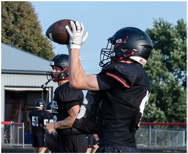 A football player catching a ball. Description generated by AI