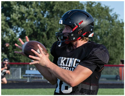 A man wearing a black jersey with the number 16 on it. Description generated by AI