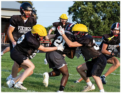 A group of football players on a field. Description generated by AI