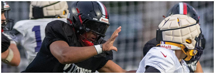 A football player wearing a black jersey with the number 93. Description generated by AI