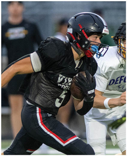 A football player in a black jersey with the number 3 on it running with a football. Description generated by AI
