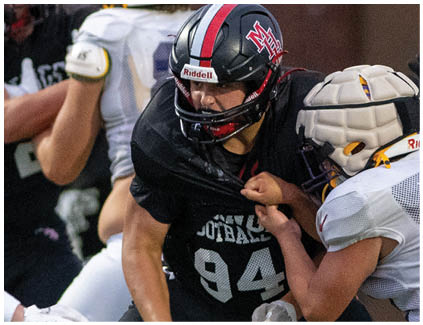 A football player wearing a black jersey with the number 94 on it. Description generated by AI