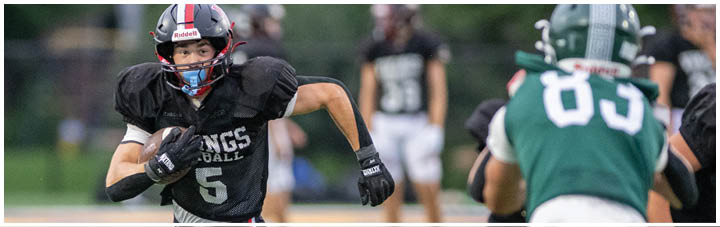 A football player running with the number 5 on his jersey. Description generated by AI
