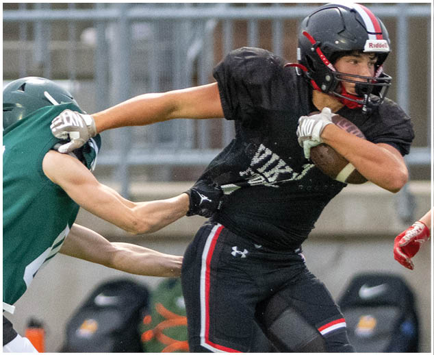 A football player in a black jersey with the number 27 on it. Description generated by AI