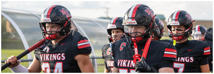 A group of football players wearing black and red uniforms. Description generated by AI