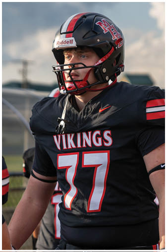A football player wearing a black and red jersey with the number 37 on it. Description generated by AI