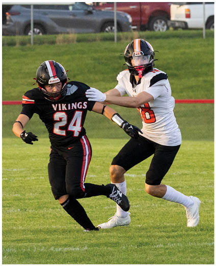 A football player wearing a black jersey with the number 24. Description generated by AI