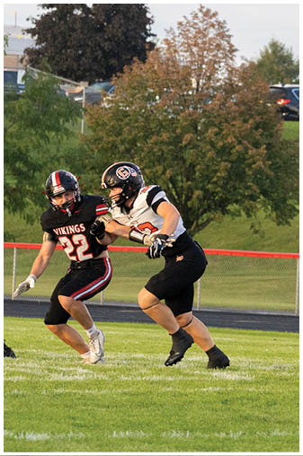 Two football players on a field. Description generated by AI