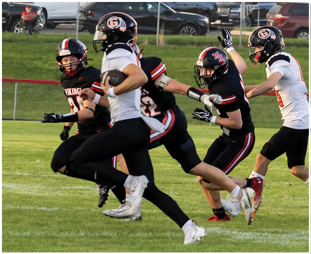 A group of football players running on a field. Description generated by AI