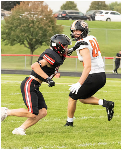 Two football players on a field. Description generated by AI