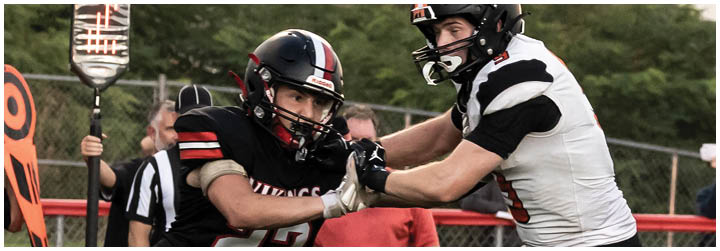 A football player wearing a black jersey with the number 22 on it. Description generated by AI