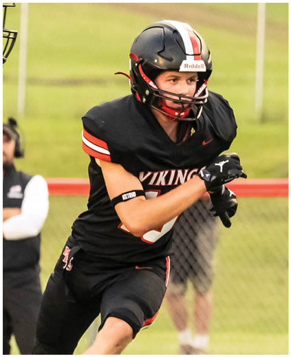 A football player wearing a black jersey with the number 13 on it. Description generated by AI