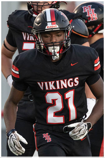 A football player wearing a black jersey with the number 21 on it. Description generated by AI